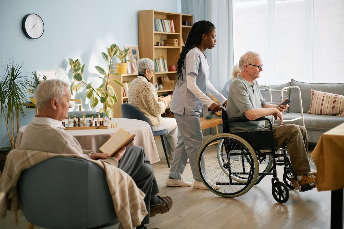 Seniors socializing and enjoying activities together in the bright, welcoming common room at Denver Adult Daycare